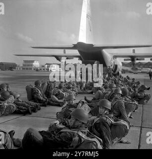 I PARACADUTISTI CADONO PRIMA DI FAR CADERE OUTRAF ABINGDON, BERKSHIRE, INGHILTERRA : uomini della 16 Parachute Brigade, British Army, mostrati dopo aver perso una breve pausa prima di salire a bordo di un aereo da trasporto C-130 dell'USAF per una caduta sopra RAF Watchfield oggi negli attuali processi congiunti di compatibilità tra la NATO britannica e quella americana. Le attrezzature e le truppe furono sganciate durante le prove, progettate per testare la cooperazione internazionale durante le esercitazioni militari della NATO. 8 novembre 1965 Foto Stock