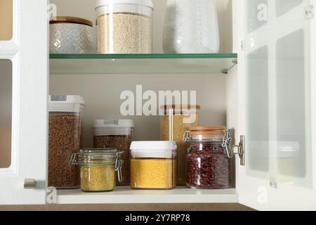 Diversi tipi di cereali e legumi in contenitori in cucina Foto Stock