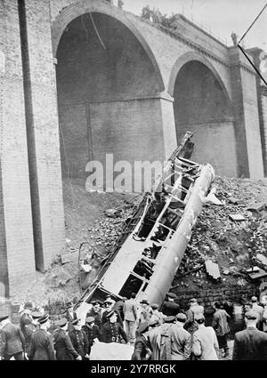 (IMMAGINE IN FILO DA MANCHESTER. ) - 10 MORTI IN COLLISIONE CON I TRENI DI MANCHESTER - 15.8,53. Almeno dieci persone sono rimaste uccise e 37 ferite quando un treno elettrico e un treno a vapore si sono scontrati a un miglio fuori dalla stazione centrale Victorial, Manchester, stamattina. - Un pullman pieno di passeggeri si è schiantato a 60 piedi nel fiume Irk. - SPETTACOLI FOTOGRAFICI I.N.P. Il pullman distrutto di uno dei treni che si trovano in parte nel fiume Irk, sotto il parapetto rotto del viadotto. - 23FO. - 70593.H. - FOTO DI NOTIZIE INTERNAZIONALI. Foto Stock