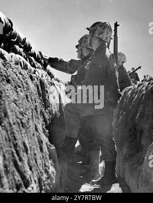 I marines in foxhole osservano la palla di fuoco del recente test di bomba atomica presso l'AEC Proving Grounds, Nevada, Stati Uniti. Successivamente esaminarono l'esplosione in avanti della bomba.24 aprile 1952 Foto Stock