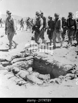 I marines passano un manichino vestito con uniforme Marine che è stato messo nell'esplosione in avanti sono per il test della bomba atomica tenutosi di recente presso l'AEC Proving Grounds in Nevada, USA.24 aprile 1952 Foto Stock