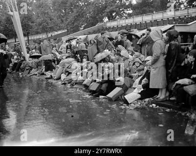 NON IMPORTA IL TEMPO 1.6.53 nonostante la pioggia, la folla lungo il Mall cresce ancora mentre i nuovi arrivi si uniscono a quelli che vi aspettano da ieri sera. La foto mostra le persone con gli ombrelli che trovano la loro giustificazione quando cade la pioggia nel Mall, Londra, Inghilterra. Foto Stock