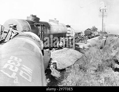 I TERRORISTI DELLA ZONA DEL CANALE COLPISCONO DI NUOVO. IL TRENO PETROLIFERO BRITANNICO È ESPLOSO. MOSTRA FOTOGRAFICI: Un piccolo gruppo di soldati britannici sta intorno al relitto del treno petrolifero del Dipartimento della Guerra che è stato fatto esplodere dai terroristi a El KEP, sei miglia a nord di Kantara, 25 miglia a nord di Ismailia sulla linea principale di Suez - Port Said. Anche se le prime sei petroliere del treno furono completamente distrutte da due potenti mine, le uniche vittime britanniche furono alcuni soldati che soffrirono di graffi. È stato il primo attacco pianificato nella zona dei canali dopo le rivolte del Cairo di tre settimane fa. Dopo il relitto del treno si trova Foto Stock