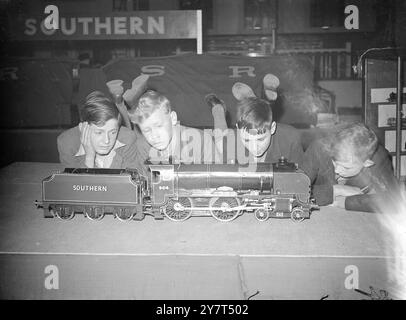 Ispezione tecnica tre giovani "esperti" affascinati da una locomotiva e da un tender splendidamente realizzati presso la mostra del Model Railway Club, aperta alla Central Hall, Westminster (Londra) fino a martedì. Oltre agli esempi di artigianato britannico sono esposte mostre provenienti da Francia, Svizzera e Olanda. 19 aprile 1949 Foto Stock