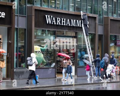 Pulitrici su scala insegna di pulizia in pioggia nel negozio Warhammer Londra Regno Unito Warhammer è un gioco da guerra in miniatura da tavolo di proprietà di Games Workshop Foto Stock