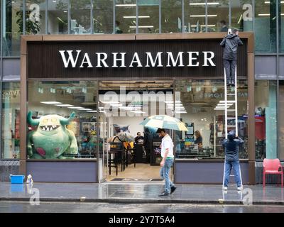 Pulitrici su scala insegna di pulizia in pioggia nel negozio Warhammer Londra Regno Unito Warhammer è un gioco da guerra in miniatura da tavolo di proprietà di Games Workshop Foto Stock