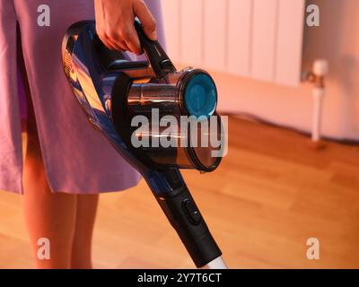 Una donna che aspira il pavimento in una casa. Primo piano Foto Stock