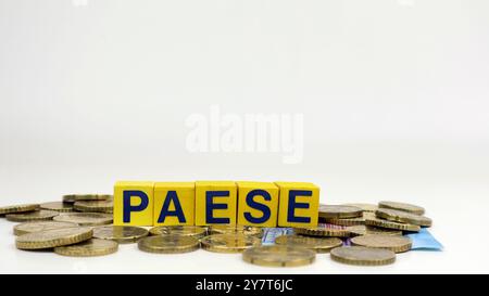 Scritto "PAESE" nella cultura italiana con cubi di legno e sfondo di molete in euro Foto Stock