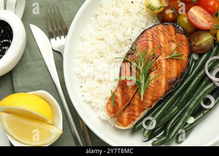 Gustosa bistecca di salmone alla griglia con riso e verdure sul tavolo, vista dall'alto Foto Stock