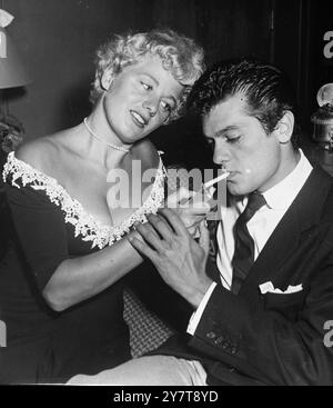 FLAME OF FRIENDSHIP suggerimento su come godersi una festa a Hollywood - lascia le partite a casa e fai venire in soccorso l'attrice Shelley Winters con un accendisigari. L'uomo fortunato in questa foto è Tony Curtis . Come Miss Winters, è un ex newyorkese. 12 ottobre 1950 Foto Stock