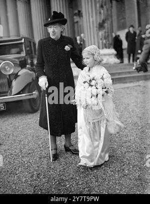 SPOSA CON Un CIRCLET DI FIORI sposati a Londra anche se entrambi hanno case scozzesi , erano Miss Robina Colquhoun , seconda figlia di 27 anni del defunto Sir Iain Colquhoun , capo del Clan , e la signora madre Colquhoun , e Mr Alan Wigan , figlio minore di Sir Roderick e Lady Wigan . La sposa prestò servizio nel Women's Royal Naval Service durante la guerra. Lo sposo , che era prigioniero in mani nemiche per parte della guerra , ora lavora per una ditta di produttori di birra . FOTO MOSTRA:- la ragazza di fiori con un ospite anziano , dopo la cerimonia nuziale a San Pietro , Eaton Square , Londra . 26 Foto Stock