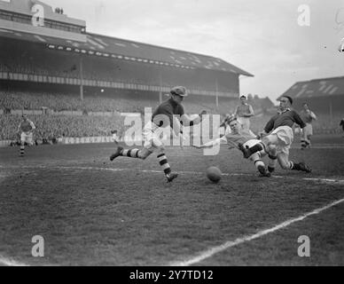 BATTENDO Un CHELSEA ATTACCA Laurie Scott, la schiena destra dell'Arsenal, crolla nel suo sforzo di salvare, ma il suo portiere, George Swindin , con le sue mani sicure diffuse per strappare la palla al Chelsea che attacca violentemente all'interno ha lasciato Hugh Billington durante la semifinale di F.A.Cup al White Hart Lane Ground, North London, oggi. la partita si è conclusa con un pareggio a due e sarà sostituita la prossima settimana. 18 marzo 1950 Foto Stock