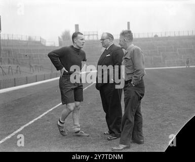 DON ROPER SUPERA IL TEST DI FITNESS - GIOCHERÀ NELLA COPPA DI DOMANI Don Roper , il centro-attaccante dell'Arsenal ha superato un test di fitness a Highbury , Londra , e si prevede che domani GIOCHERÀ contro il Leeds United nel sesto round della competizione F.A. Cup . Roper è tornato in squadra la settimana scorsa dopo due mesi di assenza a causa di un infortunio alla coscia. Da allora ha ricevuto cure per un infortunio all'altra coscia. Roper era l'unico giocatore dubbio dell'Arsenal per la partita di domani. LE IMMAGINI MOSTRANO:- DON ROPER (a sinistra) che parla con il manager degli Arseanal TOM WHITAKER (al centro) e con l'allenatore BILLY MILNE durante la t Foto Stock