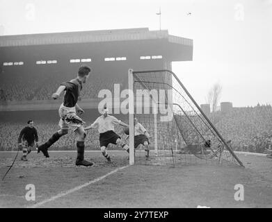 NELLA BRECCIA AL portiere dell'HIGHBURY Arsenal GEORGE SWINDIN (a sinistra), osserva in modo allarmante una certa distanza fuori dal suo gol mentre la palla si libra vicino alla linea della porta dopo un breve corto di Wilson (in primo piano), Burnley fuori sinistra, durante la partita del quinto round F.A.Cup a Highbury, Londra. La palla è stata sgomberata da Laurie Scott (sfondo destro), la schiena destra dell'Arsenal, davanti alla quale si vede Joe Mercer, la metà sinistra dell'Arsenal. 11 febbraio 1950 Foto Stock