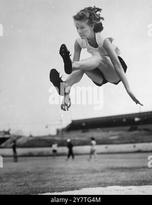 VOLA ATTRAVERSO L'ARIA Judy Canty, 18 anni, del nuovo Galles del Sud, una delle nove principali atlete australiane che sono state selezionate per rappresentare il paese nelle partite dell'Impero ad Auckland, nuova Zelanda, a febbraio, saltando in volo in una pratica di salto in largo. Detiene il titolo australiano di salto radiotelevisivo con una distanza di 18 piedi 6 1/2 pollici. 26 gennaio 1950 Foto Stock