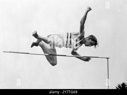 AIRBORNE BRITISHER 30 gennaio 1950 altezza armi, ginocchia nascoste, Ronald Cecil Pavitt, 23 di Wembley, Middlesex, salta oltre il bar in un "Western Roll" mentre pratica per gli Empire Games nel campo inglese di Ardmore, Auckland, nuova Zelanda. Pavitt, nella squadra inglese, ha un salto in alto di 6 fett 6 pollici al suo credito. Gli Empire Games iniziano ad Auckland questa settimana. Foto Stock