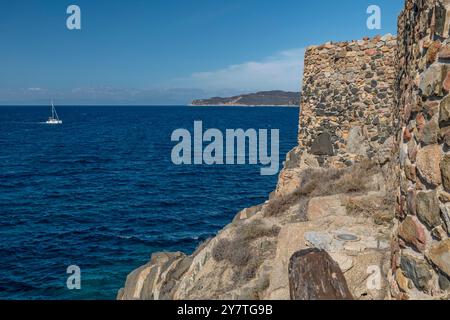 Un catamarano bianco naviga vicino alla Fortezza Vecchia a Villasimius, in Sardegna Foto Stock