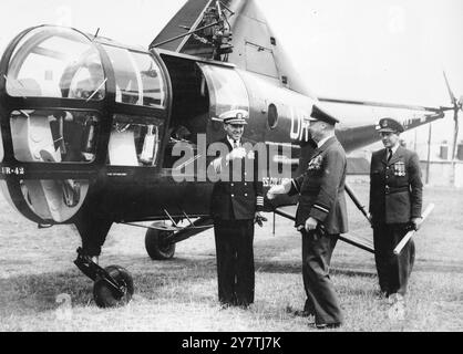 L'ELICOTTERO ATTERRA E FA LA STORIA. Il capitano e R McLean, Jnr, comandante dell'incrociatore statunitense Columbus, è accolto dal vice maresciallo Spencer (a destra), capo del 19 Group Coastal Command, RAF, dopo aver fatto la storia con un elicottero che è atterrato alla base aerea di Mount Batten. Fu la prima volta che un elicottero fece atterrare alla base aerea, che divenne famosa per i lavori di salvataggio di Sunderland effettuati da lì durante la guerra. Il capitano McLean in seguito tornò a Columbus nell'Hamoaze, vicino a Plymouth, Devon, da dove decollò per la visita ufficiale. 5 luglio 19 Foto Stock