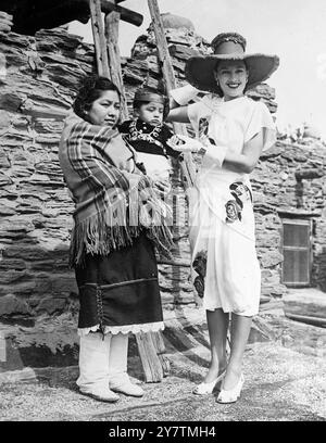 Uno squaw indiano Hopi e il suo incontro papooso una modella che indossa un abito con stampa papoosa indiana esposto in una sfilata di moda sul bordo del Grand Canyon , Arizona , l'abito USAThe è stato disegnato da Dorothy o'Hara e modellato da Lois Ward . Tutte le mode in vista sono state attribuite all'ispirazione del sentiero di Santa Fe e dei primi giorni dell'America occidentale, il 28 settembre 1946 Foto Stock