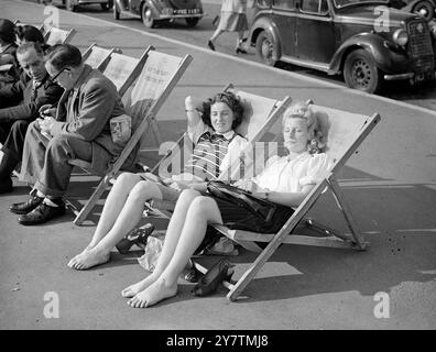 Scarpe a Brighton - il giorno più caldo dell' anno a BrightonBrighton ha registrato il giorno più caldo dell' anno con una temperatura di 80 gradi . Grandi folle affluivano sulla costa e le spiagge di Brighton erano piene di turisti che approfittavano dell'inaspettata ondata di caldo autunnale . Spettacoli fotografici: Due ragazze londinesi Shirley o'Sullivan (a sinistra) e Vicki Forrest (a destra) si tolgono le scarpe e partecipano a un pisolino al sole brillante sul lungomare di Brighton , West Sussex 29 settembre 1946 Foto Stock