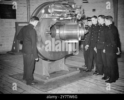 SCOPRI I GRANDI CANNONI DELLA MARINA mostre fotografiche: Membri di una classe di artiglieria navale che studiano la breccia di un cannone navale da 15 pollici in un deposito di addestramento dei Royal Marines in un porto nel sud dell'Inghilterra. 31 marzo 1940 Foto Stock