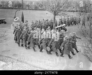 ADDESTRARE GLI "ALL ROUNDERS" DELLE FORZE BRITANNICHE non ha praticamente alcun lavoro in tempo di guerra che non sia svolto dai membri dei Royal Marines, probabilmente la forza più versatile del Regno Unito. I Royal Marines prestano servizio sulle navi ando n shore in tutto il mondo. Gli uomini sono addestrati in molti tipi di artiglieria, nell'uso di proiettori, in tutte le forme di segnali, nel lavoro di fanteria e anche come piloti per il Fleet Air Arm. Queste foto sono state scattate presso il deposito di addestramento dei Royal Marines in un porto nel sud dell'Inghilterra, dove molte giovani reclute stanno ora imparando i vari compiti del reggimento. Spettacoli fotografici: Royal Mar Foto Stock