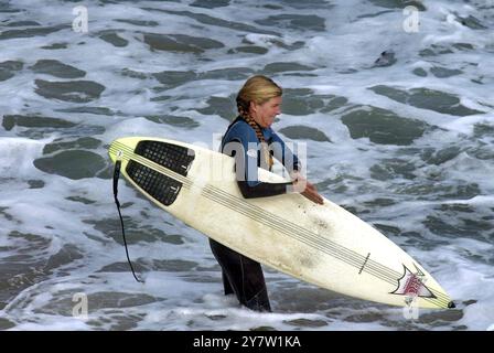 Santa Cruz, California: Una surfista aspetta di cavalcare le onde al largo di Lighthouse Point. Il surf, lo sport un tempo dominato dagli uomini, ha guadagnato popolarità tra le donne nel corso degli anni e recentemente con il film estivo "Blue Crush", una storia di ragazze surfiste ambientate alle Hawaii. 20 ottobre 2002 Foto Stock