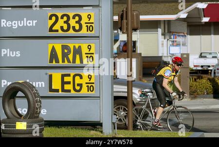 Menlo Park, California: Il proprietario della stazione di Menlo-Atherton Shell si è divertito con l'alto prezzo di più e l'insegna del gas premium. Il proprietario della stazione di servizio ha fatto la stessa cosa l'anno scorso con il cartello del prezzo. Il prezzo di Plus è di $2,43 e il premio è di $2,53. 17 maggio 2004 Foto Stock