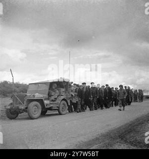 "RUSSI" IN ABITI CIVILI CATTURATI VICINO A METZ foto mostra: Una jeep conduce una insolita colonna di prigionieri catturati nell'area di Metz. Riferiti agli Alleati dalla FFI, gli uomini dichiararono di essere russi che furono catturati a Smolensk, costretti nell'esercito tedesco e fuggiti indossando abiti civili. 13 settembre 1944 Foto Stock