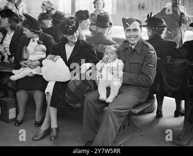 I BELGI RIMPATRIATI TORNANO NEL LORO PAESE Un gruppo di 250 belgi rimpatriati lasciò la stazione di Fenchurch Street, Londra, in viaggio per il Belgio. Tra questi vi erano bambini nati in Gran Bretagna che per la prima volta si recavano nel proprio paese. Mostra fotografici: Robert Bruno Young, di sette mesi, tra le braccia del padre Clement Young, venuto in Inghilterra da Mauritius, si unì alla RAF e in seguito incontrò sua moglie Raymonde (a sinistra) rifugiata belga. Viaggiò fino a Tilbury con lei per dire addio fino a quando non ebbe finito il suo servizio con la Royal Air Force. 20 giugno 1945 Foto Stock