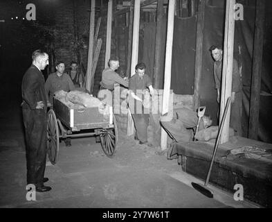 LONDRA GUARISCE LE SUE CICATRICI: INIZIA IL LAVORO SULL'ABBAZIA DI WESTMINSTER i lavori sono iniziati sulla rimozione di 80.000 sacchi di sabbia che proteggevano i preziosi monumenti dell'Abbazia di Westminster, Londra, e si spera che entro dodici mesi l'Abbazia sarà riportata alla sua gloria precedente. I danni da raid aerei stimati a £ 135.000, ma le efficaci precauzioni contro l'azione nemica hanno salvato ogni aspetto di interesse storico. Le vetrate più antiche furono rimosse all'inizio della guerra, e il resto non è stato gravemente danneggiato, includono la casa del decano, i chiostri e i piccoli chiostri e gli edifici della scuola di Westminster An Foto Stock