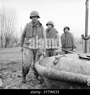 GLI ALLEATI INTENSIFICANO LE ESERCITAZIONI DI ATTRAVERSAMENTO DEL FIUME AD OVEST DEL RENO con le forze britanniche, canadesi e americane che si affacciano sul Reno da Arnhem a Coblenz, e la testa di ponte a Remagen che cresce ogni giorno, gli Alleati hanno integrato le esercitazioni di attraversamento del fiume ad ovest dell'ultima linea di difesa naturale della Germania sul fronte occidentale. Spettacoli fotografici: Le truppe del settimo esercito provano un fiume che attraversa il Reno ad ovest, da sinistra a destra, trasportando il loro gommone d'assalto di gomma, sono Osmus Leonard privato di prima classe 322, di Alameda Avenue, Astroia, Oregon, T/5 Elmore Scafibel, di Natalbany, Louisiana, e il sergente George Prengress, Foto Stock