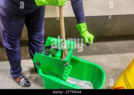 Servizi di pulizia donna con secchio strizzatore per mop, pulizia professionale operaia afroamericana Foto Stock