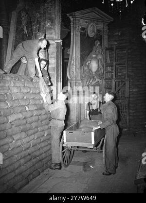 LONDRA GUARISCE LE SUE CICATRICI: INIZIA IL LAVORO SULL'ABBAZIA DI WESTMINSTER i lavori sono iniziati sulla rimozione di 80.000 sacchi di sabbia che proteggevano i preziosi monumenti dell'Abbazia di Westminster, Londra, e si spera che entro dodici mesi l'Abbazia sarà riportata alla sua gloria precedente. I danni da raid aerei stimati a £ 135.000, ma le efficaci precauzioni contro l'azione nemica hanno salvato ogni aspetto di interesse storico. Le vetrate più antiche furono rimosse all'inizio della guerra, e il resto non è stato gravemente danneggiato, includono la casa del decano, i chiostri e i piccoli chiostri e gli edifici della scuola di Westminster An Foto Stock