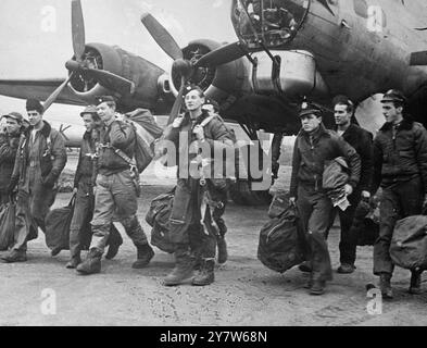 TORNATI DAL WITTENBERGE RAID Photo Show: Gli uomini dell'8th Air Force 92nd Bomber Group attraversano un aerodromo britannico dopo essere atterrati dal grande raid sulle comunicazioni ferroviarie tedesche, il loro obiettivo era Wittenberge, e nessuna delle loro Flying Fortresses mostrava segni di attacchi al termine del raid. 23 febbraio 1945 Foto Stock