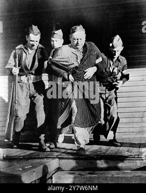 I Red Raiders conquistarono il potere nella città degli Stati Uniti più tardi nella campagna anticomunista di Amrica , fu un realistico raid nella città di Mosinee , Wisconsin , da parte delle forze rosse , che spararono al capo della polizia , trascinarono il sindaco fuori dal letto e lo costrinsero a dichiarare la città sotto il dominio comunista , e gettarono molti cittadini in un campo di concentramento . Foto: Il raid "comunista" non aveva nulla di realismo. Qui il sindaco di Mosinee Ralph Kronenwetter , viene condotto in un "campo di concentramento" , con gli occhi sonnolenti e rivestito di pigiama e vestaglia. 3 maggio 1950 Foto Stock