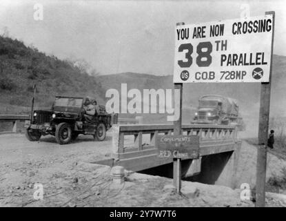 I veicoli coreani del WarUN che passano sopra un ponte al 38° confine parallelo , durante l'attuale ritiro dalle orde cinesi , sono incontrati con questo cartello che recita 'con complimenti della Cina Rossa' 17 dicembre 1950 Foto Stock