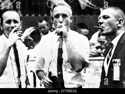 Space Centre , Houston: Qui sono mostrati i giubilanti direttori di volo Chris Kraft (a sinistra), John Hodge (al centro) e Gene Kranz (a destra) che pompano sugli scali del Centro di controllo missione dopo il recupero sicuro di ieri di Gemini-5 e degli astronauti Gordon Cooper e Pete Conrad . Questi tre uomini supervisionarono tre turni di personale di controllo missione e furono responsabili del controllo generale della missione 30 agosto 1965 Foto Stock