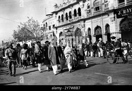 La Lega musulmana ha organizzato incontri di sfida a Lahore. I leader marciarono verso il Segretariato e quando furono scattate queste foto, Begum Shah Nawaz e l'ex ministro Shaukat Hyat Khan, che erano stati recentemente rilasciati, furono arrestati una seconda volta. Ci sono stati 62 arresti. Le donne musulmane, per lo più a Purdah, presero parte alle dimostrazioni di sfida e il gas lacrimogeno fu utilizzato per disperdere la folla. Qui si vedono Begum Tassadaq Hussain e leaguari di spicco con bandiere della Lega che marciano in processione. Alcuni di loro sono stati arrestati in seguito. (Didascalia originale) 8 febbraio 1947 Foto Stock