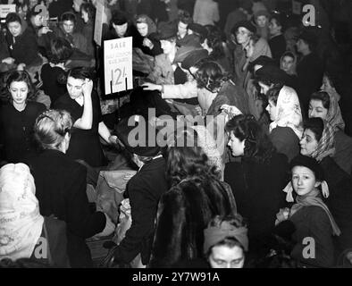 NO MANS ATTERRA DURANTE LE VENDITE PRIMAVERILI 5 gennaio 1948 gli amanti dello shopping alla ricerca di occasioni che gettano il fondo di tutti i record pro-guerra, affollano oggi questo negozio del West End (C A Modes, Oxford Street), durante la prima mattina dei saldi primaverili di Londra. Il "nuovo look" del 1948 ha ridotto sia il prezzo che il valore coupon di molti articoli di abbigliamento femminile. Foto Stock