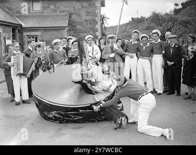 La 'Obby' Oss di Padstow riparte nella parata del giorno di maggio - la tradizionale 'Obby' Oss fu ancora una volta il fulcro della parata annuale del giorno di maggio di Padstow ( North Cornwall ) . Seguiti da balli e canti cittadini e altri che suonano gli accordi , preceduti dal solito teaser con un bastone per infastidirla , l'"Obby" Oss ha scatenato le celebrazioni della giornata. La leggenda dice che questo fantastico cavallo era uno dei tanti che la gente di Padstow usava sfilare sulle cime della scogliera quando fu avvistata l'Armada spagnola. Da lontano, sembrava un esercito a cavallo, e si diceva che l'Armada fosse spaventata Foto Stock