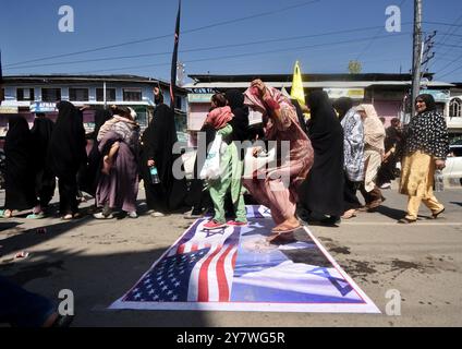 Budgam, Jammu e Kashmir, India. 29 settembre 2024. I musulmani sciiti del Kashmir camminano sopra una foto del primo ministro israeliano Benjamin Netanyahu e della bandiera israeliana durante una protesta contro l'uccisione del capo Hezbollah Hassan Nasrullah a Magam, a circa 25 km a nord di Srinagar, la capitale estiva del Kashmir indiano, il 29 settembre. (Credit Image: © Mubashir Hassan/Pacific Press via ZUMA Press Wire) SOLO PER USO EDITORIALE! Non per USO commerciale! Foto Stock