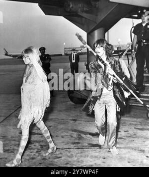 George Harrison e sua moglie, Patti Boyd, fanno una coppia colorata all'arrivo all'aeroporto di New York. George sta portando un tubo di pace donatogli dagli hippy a San Francisco. 9 agosto 1967 Foto Stock