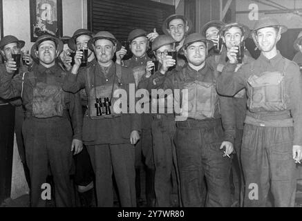 I soldati alzano un bicchiere - il soldato con il binocolo è un tenente e quello al centro ha i distintivi dei Royal Engineers sul collare - tutti indossando le loro maschere a gas . ©TopFoto Foto Stock