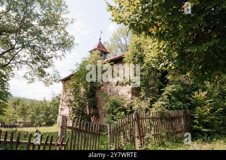 Enigmatiche rovine di una chiesa dimenticata, abbracciate dai lussureggianti verdi della natura. Foto Stock