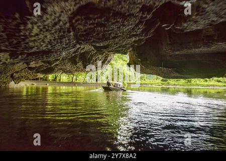 Viaggia attraverso una grotta sul Tam Coc fiume di Ninh Binh, Vietnam. Foto Stock