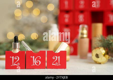 Calendario dell'Avvento di Natale con prodotti per il trucco sul tavolo, primo piano Foto Stock