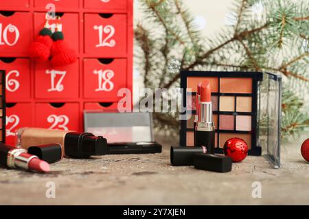 Cosmetici decorativi con calendario dell'Avvento di Natale in tavola, primo piano Foto Stock