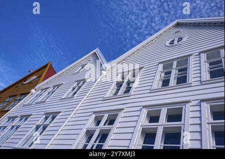 Tradizionali case in legno sotto un cielo blu con tetti a spiovente e finestre multiple in una città vecchia soleggiata, Bryggen, Bergen, Vestland, Norvegia, Europa Foto Stock