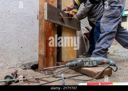 L'operatore sta installando e assemblando casseforme a colonna per il riempimento del calcestruzzo nel cantiere. Cassaforma a colonna in legno fissata alla muratura mediante perni. Con Foto Stock